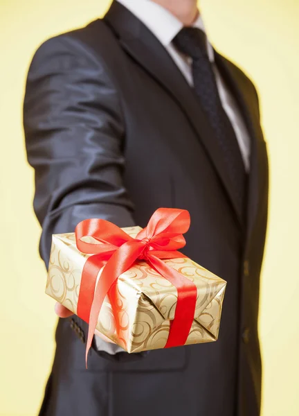 Mano masculina sosteniendo un regalo — Foto de Stock