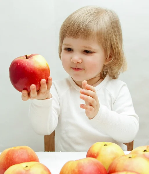 Usmívající se dítě drží jablko — Stock fotografie
