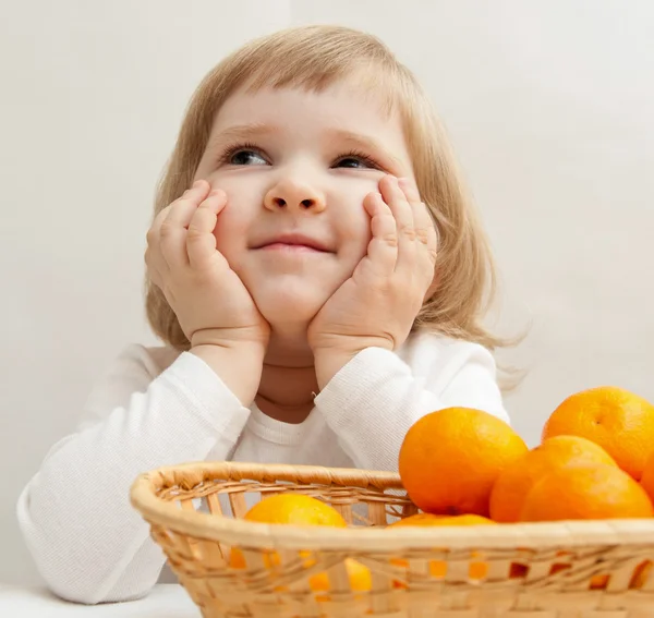 Little girl with tangerines — Stock Photo, Image