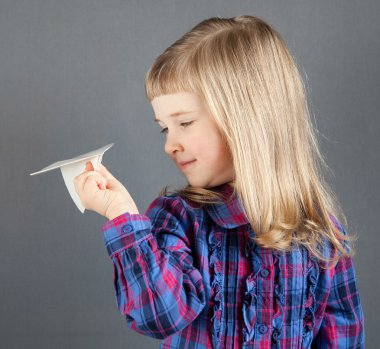 Küçük kız uçan kağıt uçak gülümseyen 
