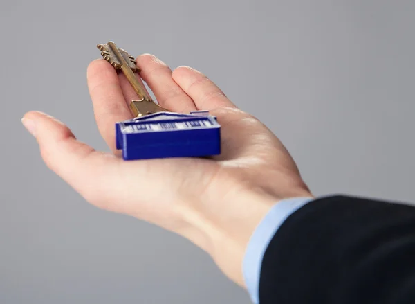 Mão do agente segurando uma chave — Fotografia de Stock