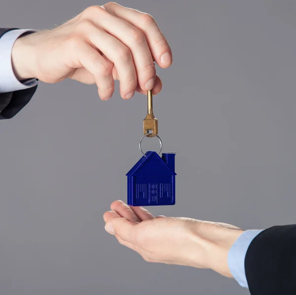 Hand passing a key to woman's hand — Stock Photo, Image