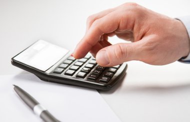 Hesap makinesini kullanarak iş adamı elinde