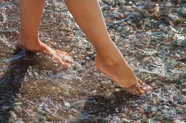 Weibliche Beine im Wasser — Stockfoto