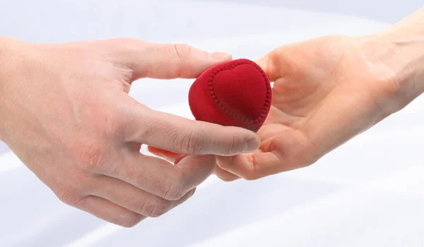 Mãos com caixa em forma de coração vermelho — Fotografia de Stock