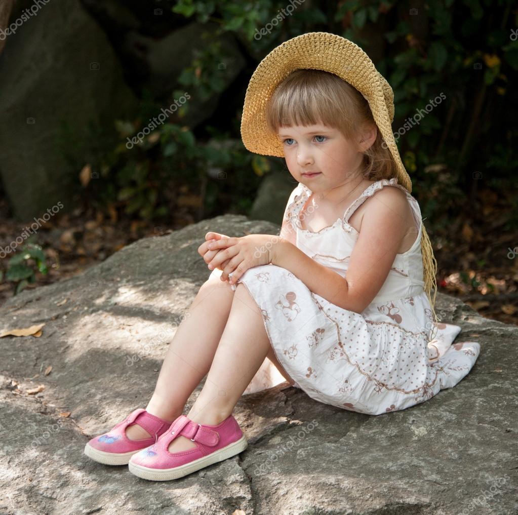 Little girl sitting on stone Stock Photo by ©zestmarina 92972538