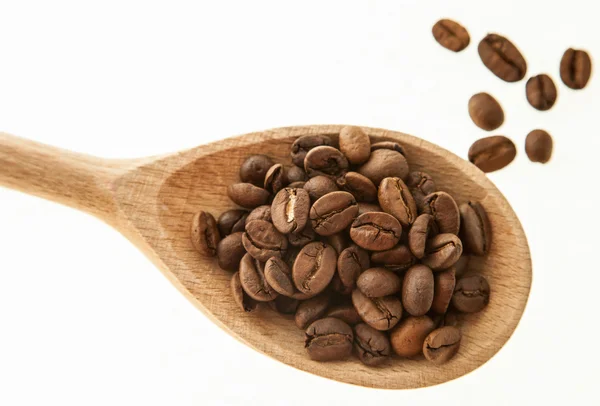Granos de café en una cuchara de madera — Foto de Stock