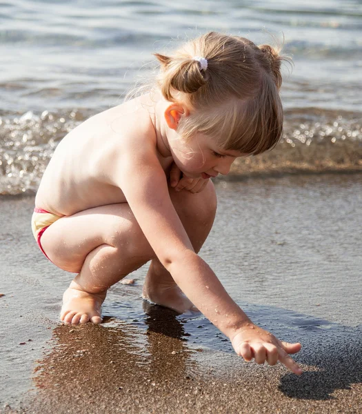 Küçük kız sahil üzerinde oynama — Stok fotoğraf