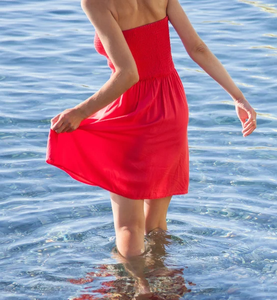 Kvinna i röd klänning i vatten — Stockfoto