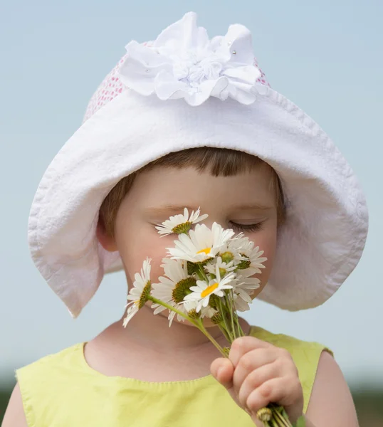 Flicka anläggning camomiles — Stockfoto