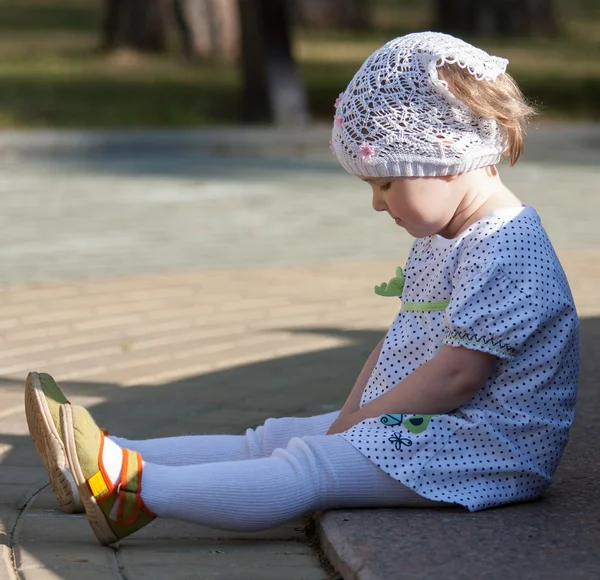Dívka sedící na chodníku — Stock fotografie