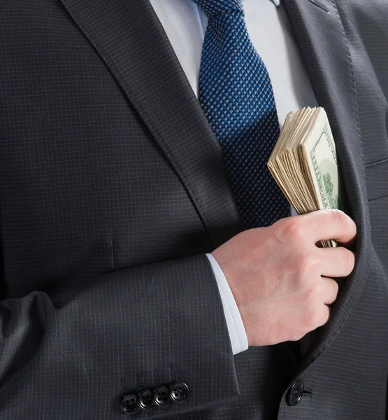 Hombre de negocios poniendo dinero en su bolsillo —  Fotos de Stock