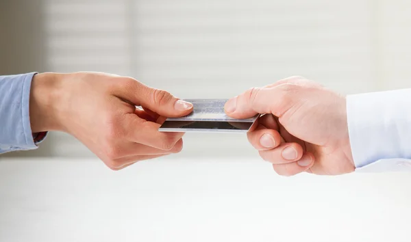 Exchanging credit card over the table — Stock Photo, Image