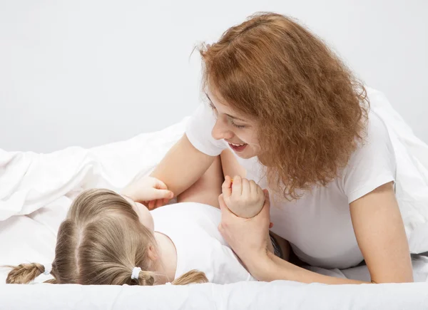 Mère et fille jouant au lit Images De Stock Libres De Droits