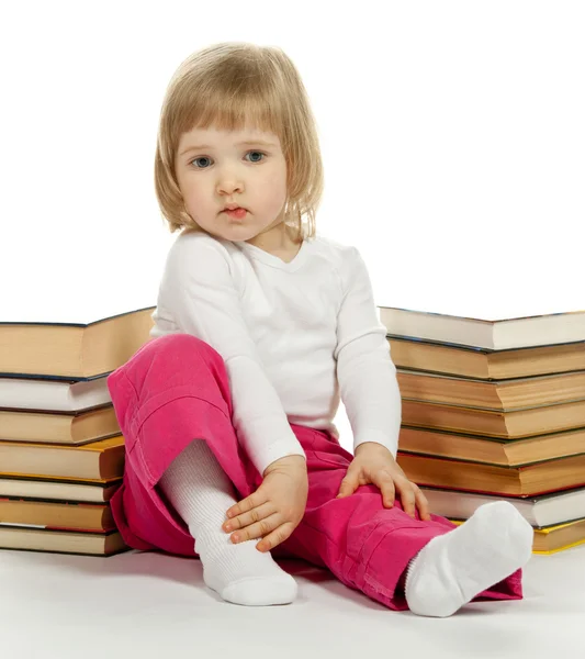 Girl sitting among books — Stock Photo, Image