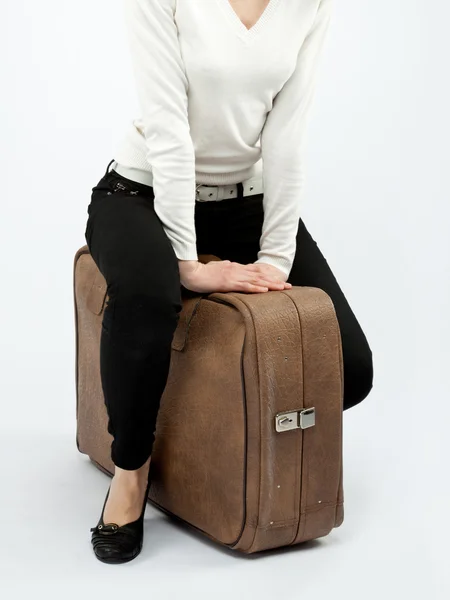 Mladá žena, sedící na velký kufr — Stock fotografie
