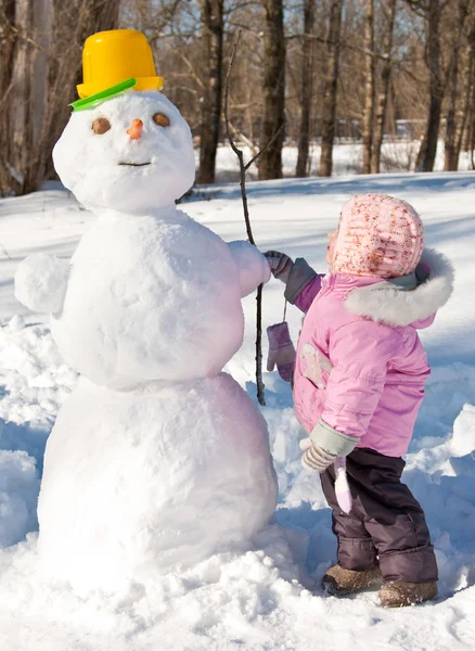 Malá holka se sněhulákem — Stock fotografie