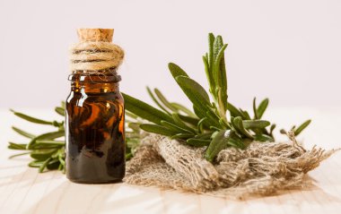 Fresh rosemary and a bottle of essential oil clipart