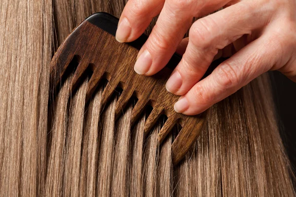 Female hand combing hair — Stock Photo, Image