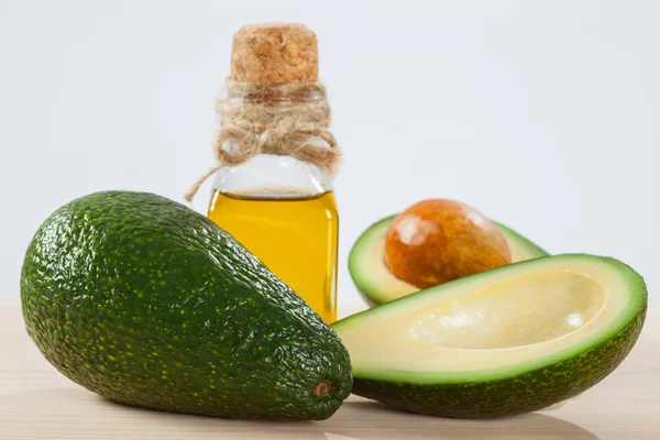 Свежий авокадо и бутылка масла — стоковое фото