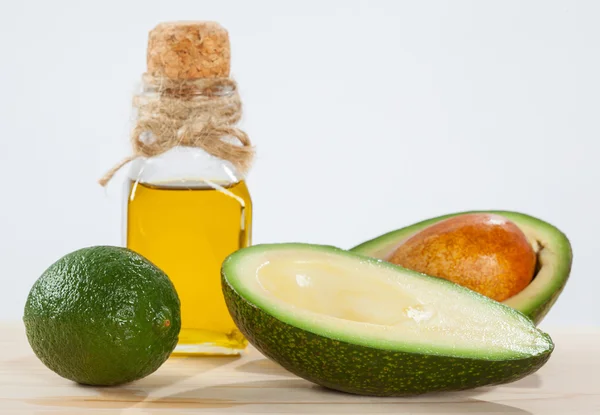 Авокадо, лайм и бутылка масла — стоковое фото