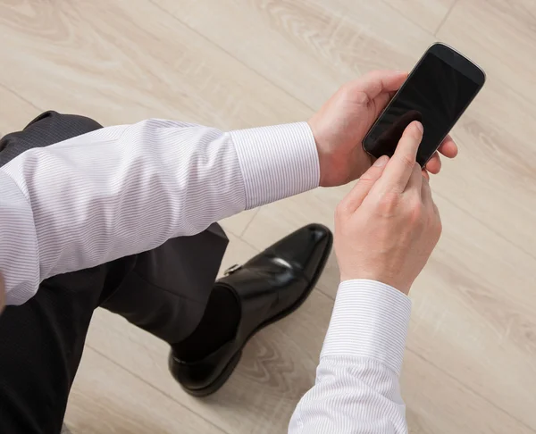 Empresario sosteniendo un celular — Foto de Stock