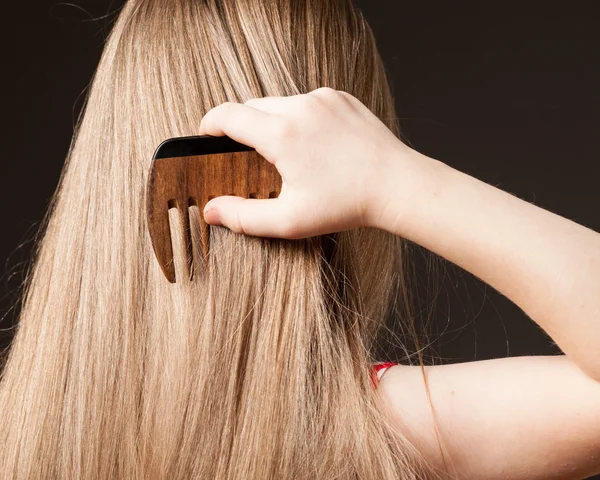 Chica peinando su pelo largo — Foto de Stock