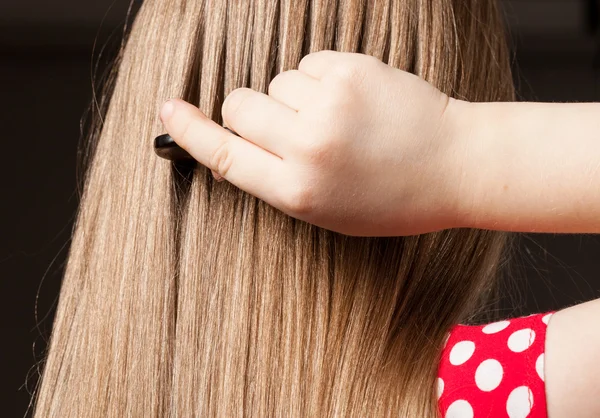 Chica peinando su pelo largo — Foto de Stock