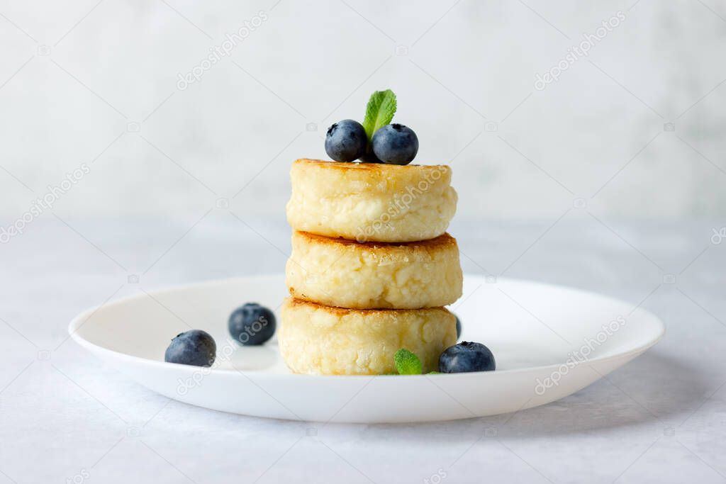 Cottage cheese pancakes, syrniki, curd fritters with fresh blueberries.