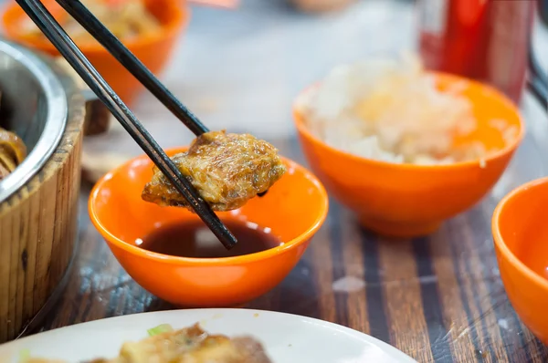 Gebratene Frühlingsrolle, gehalten von Stäbchen an einem hong kong dai pai dong — Stockfoto