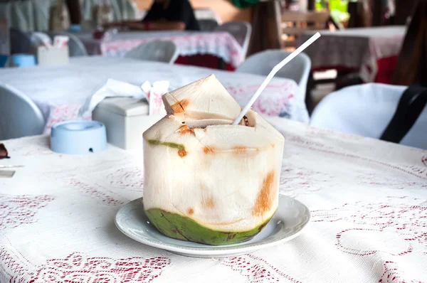 Frische Kokosnuss mit Trinkhalm in einem thailändischen Restaurant — Stockfoto