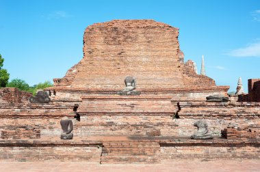 Temple ruins and damaged Buddha statue at Wat Mahathat, Ayutthaya, Thailand