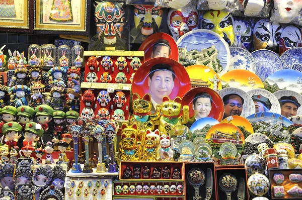 Uma barraca de lembrança em um mercado noturno de Pequim vendendo placas de rosto Xi Jinping e outros lixo kitsch . — Fotografia de Stock