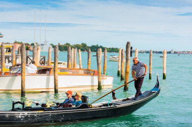 Venedik, İtalya - 23 Eylül 2019 Gondolcu Venedik, İtalya 'da gondolla turistleri taşıyor. Venedik manzaralı geleneksel gondol turu.