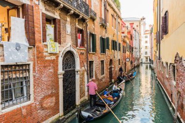 Venedik, İtalya - 23 Eylül 2019 Gondolcu Venedik, İtalya 'da gondolla turistleri taşıyor. Geleneksel Venedik gondolu ünlü kanalda. Güzel Venedik manzarası.