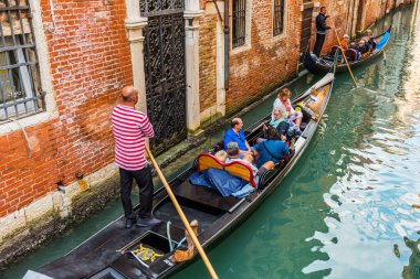 Venedik, İtalya - 23 Eylül 2019 Gondolcu Venedik, İtalya 'da gondolla turistleri taşıyor. Geleneksel Venedik gondolu ünlü kanalda. Güzel Venedik manzarası.