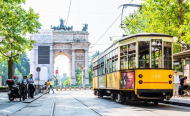 MILANO, İtalya - 3 Temmuz 2019: Milano, İtalya 'da nostaljik sarı tramvayla Barış Kemeri (Arco della Pace) manzarası.