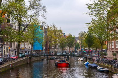 AMSTERDAM, NETHERLANDS - 25 Eylül 2017 Amsterdam Şehir Merkezi. Köprüsü olan Amsterdam Kanalları ve tipik Hollanda Evleri 'nin güzel manzarası. Amsterdam, Hollanda.