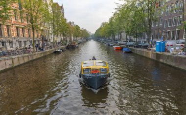 AMSTERDAM, NETHERLANDS - 25 Eylül 2017 Amsterdam Şehir Merkezi. Köprüsü olan Amsterdam Kanalları ve tipik Hollanda Evleri 'nin güzel manzarası. Amsterdam, Hollanda.