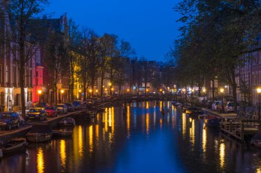 AMSTERDAM, NETHERLANDS 25 Eylül 2017 Amsterdam. Amsterdam 'ın gece manzarası, kanal, köprü ve tipik Hollanda evleri. Amsterdam, Hollanda.
