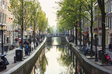 AMSTERDAM, NETHERLANDS - 25 Eylül 2017 Amsterdam Şehir Merkezi. Köprüsü olan Amsterdam Kanalları ve tipik Hollanda Evleri 'nin güzel manzarası. Amsterdam, Hollanda.