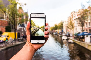 Amsterdam 'da cep telefonuyla fotoğraf çeken bir turist. Hollanda.