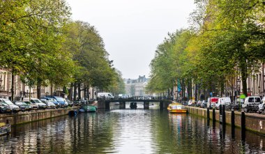 AMSTERDAM, NETHERLANDS - 25 Eylül 2017: Amsterdam kanalı, köprüsü ve tipik Hollanda evleriyle şehir manzarası. Amsterdam, Hollanda.