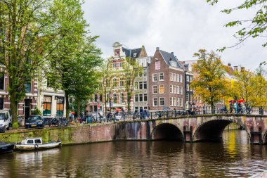AMSTERDAM, NETHERLANDS - 25 Eylül 2017 Amsterdam Şehir Merkezi. Köprüsü olan Amsterdam Kanalları ve tipik Hollanda Evleri 'nin güzel manzarası. Amsterdam, Hollanda.