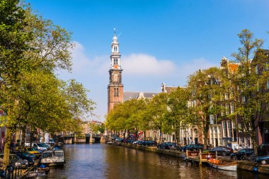AMSTERDAM, NETHERLANDS - 27 Eylül 2017: Westerkerk Kilisesi (Batı Kilisesi) ve Amsterdam 'daki kanal manzarası. Westerkerk, Hollanda Protestan Kalvinizmi içinde ıslah olmuş bir kilisedir..