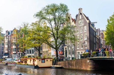 AMSTERDAM, NETHERLANDS - 25 Eylül 2017 Amsterdam Şehir Merkezi. Köprüsü olan Amsterdam Kanalları ve tipik Hollanda Evleri 'nin güzel manzarası. Amsterdam, Hollanda.