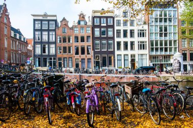 AMSTERDAM, NETHERLANDS - 25 Eylül 2017 Amsterdam Şehir Merkezi. Köprüsü olan Amsterdam Kanalları ve tipik Hollanda Evleri 'nin güzel manzarası. Amsterdam, Hollanda.