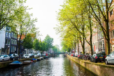 AMSTERDAM, NETHERLANDS - 25 Eylül 2017 Amsterdam Şehir Merkezi. Köprüsü olan Amsterdam Kanalları ve tipik Hollanda Evleri 'nin güzel manzarası. Amsterdam, Hollanda.