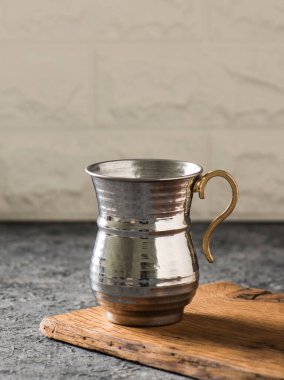 Geleneksel gümüş metal bardak ahşap arka planda.