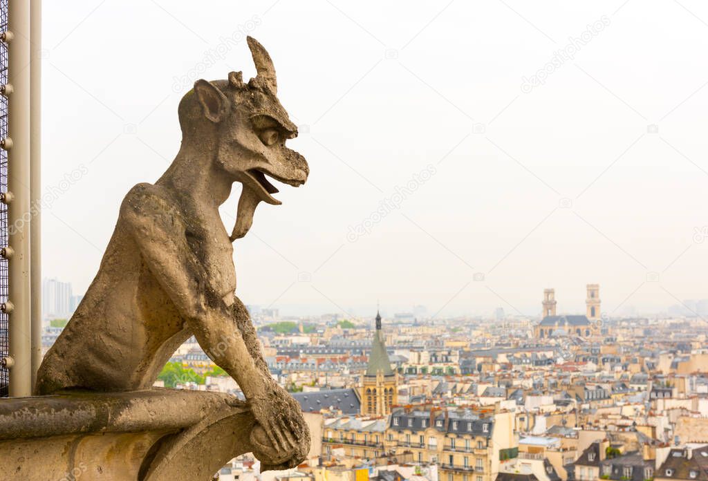 Gargoyle on Notre Dame de Paris Cathedral with view of Paris. France.